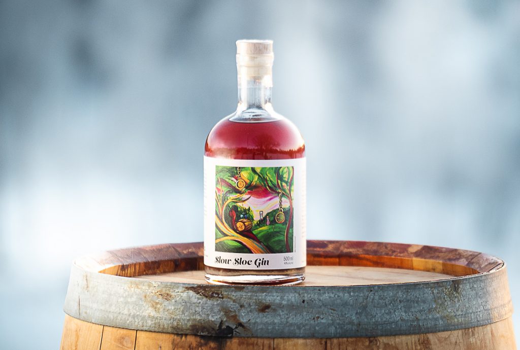 Hernö Slow Sloe Gin flaska står på ett lagringsfat.